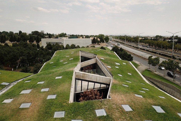 The striking geometric contours and bold green roof of the MEAMA Coffee Factory in Tbilisi, Georgia keeps the building cooler in summer and warmer in winter.