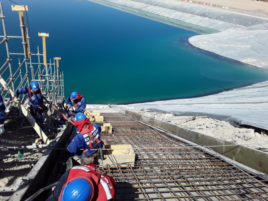 The repair and expansion of the Spence mine tailings dam in Chile started with a protective layer of concrete to protect the earth-fill embankment dam.
